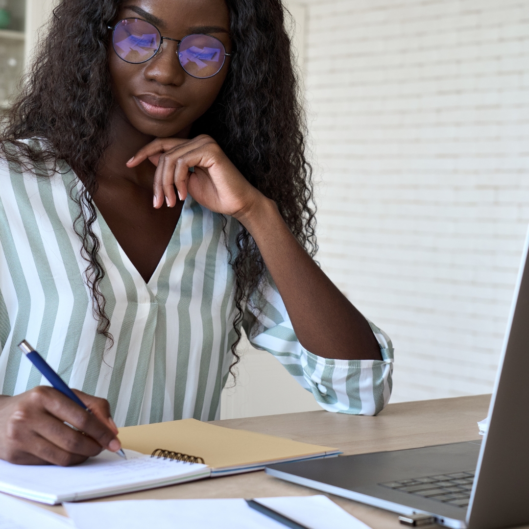 girl on laptop and taking notes