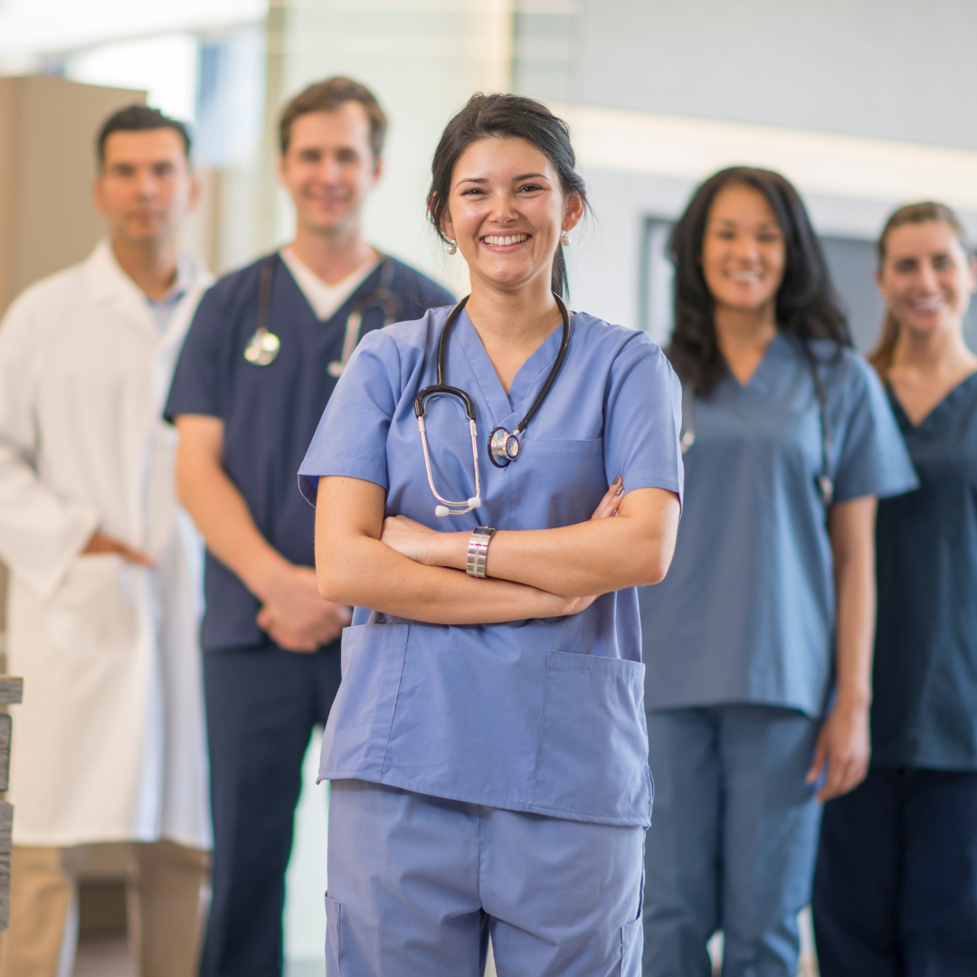 group of nurses and doctors standing together while smiling
