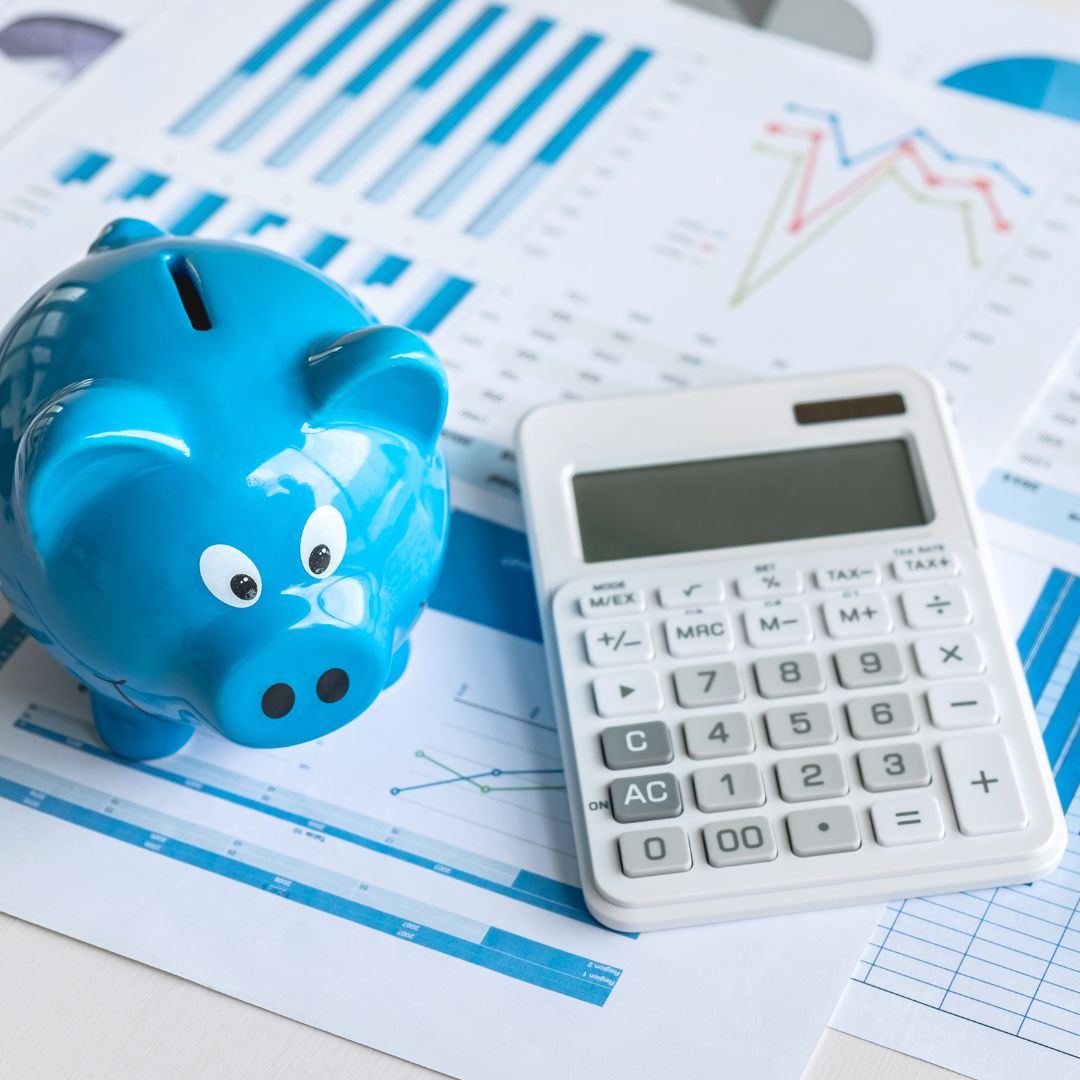 blue piggy bank sitting next to a calculator