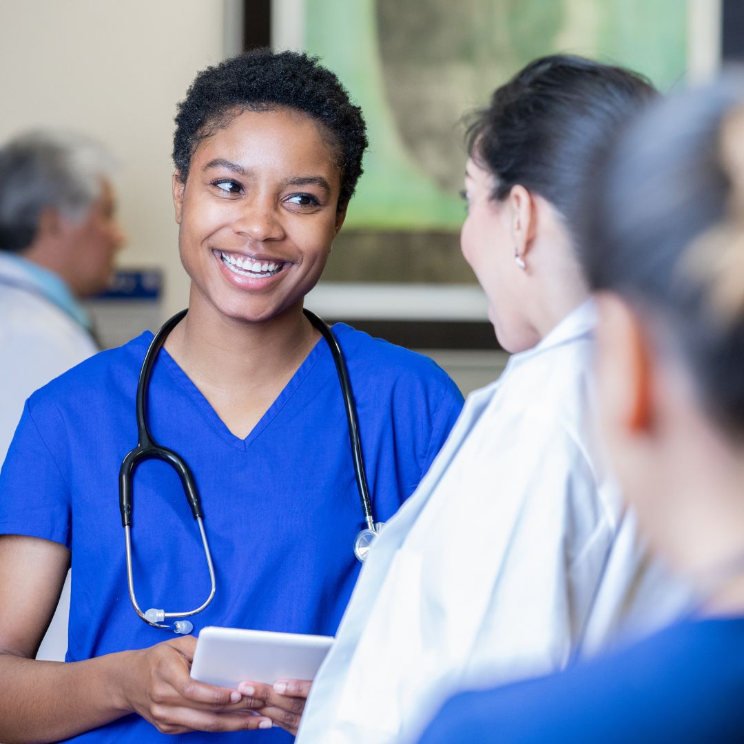 smiling nurse taking to a doctor