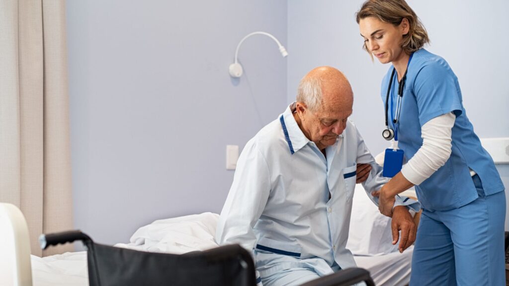 Nurse helping elderly patient from bed