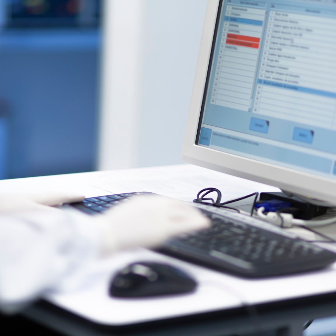 A nurse typing on a computer.