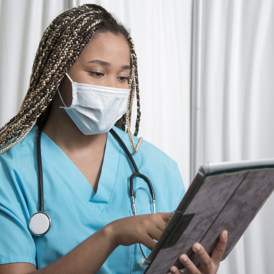 A nurse looking at an iPad.