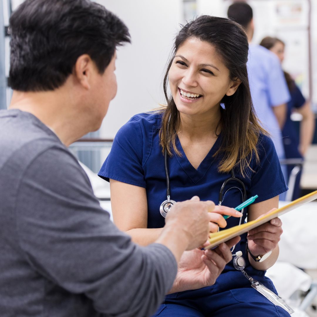 smiling nurse handing patient paperwork