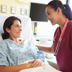 woman nurse talking to patient in hospital