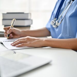 nurse studying and writing in a notebook