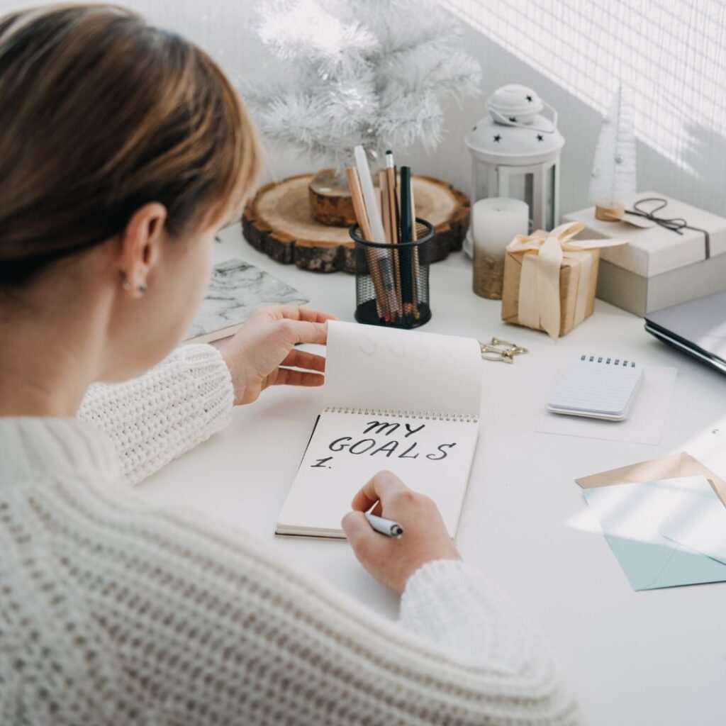 a woman writing down her goals