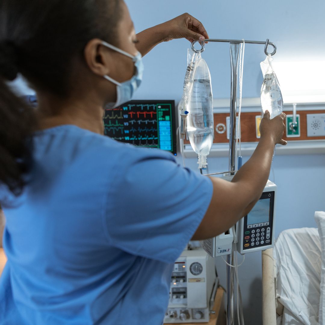 nursing student hanging up IV bag