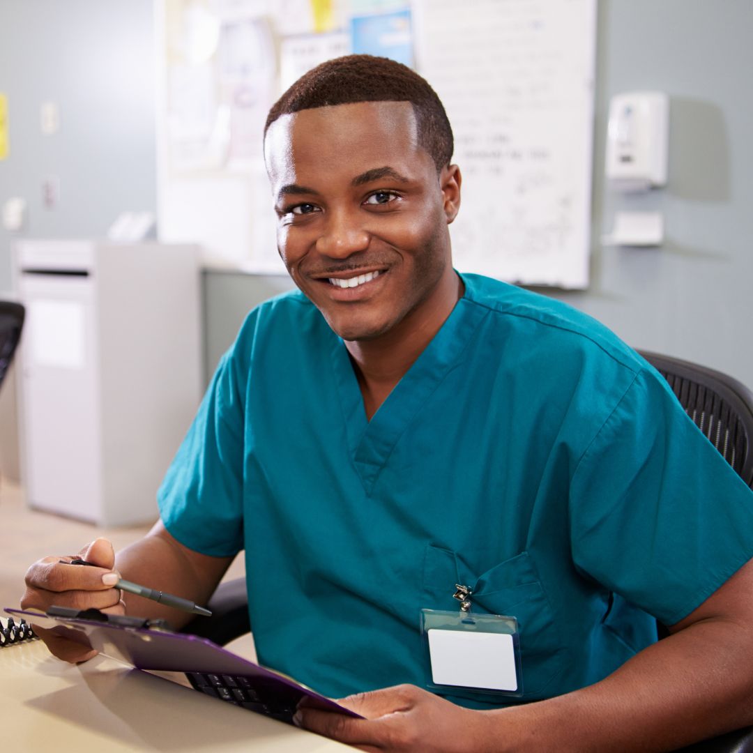 smiling nursing student at computer with clipboard