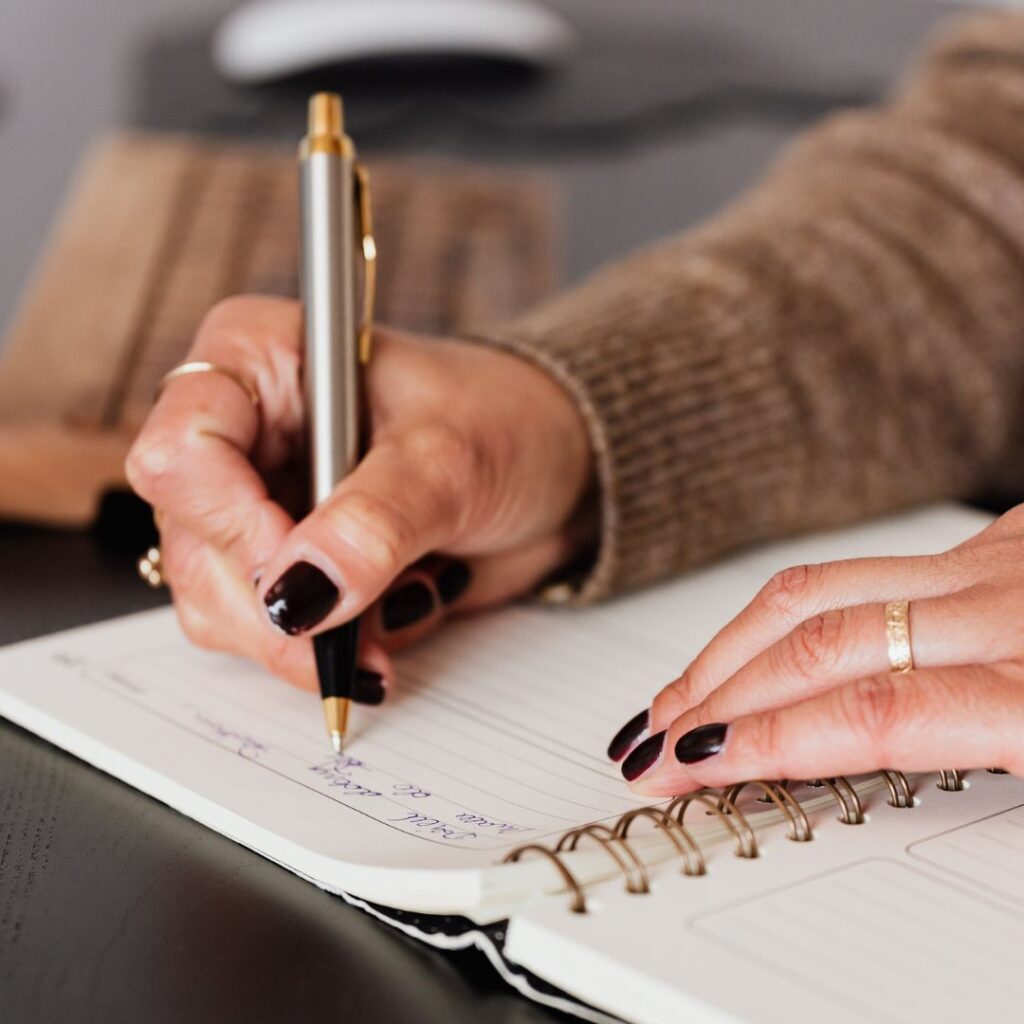 Student writing out tasks in notebook