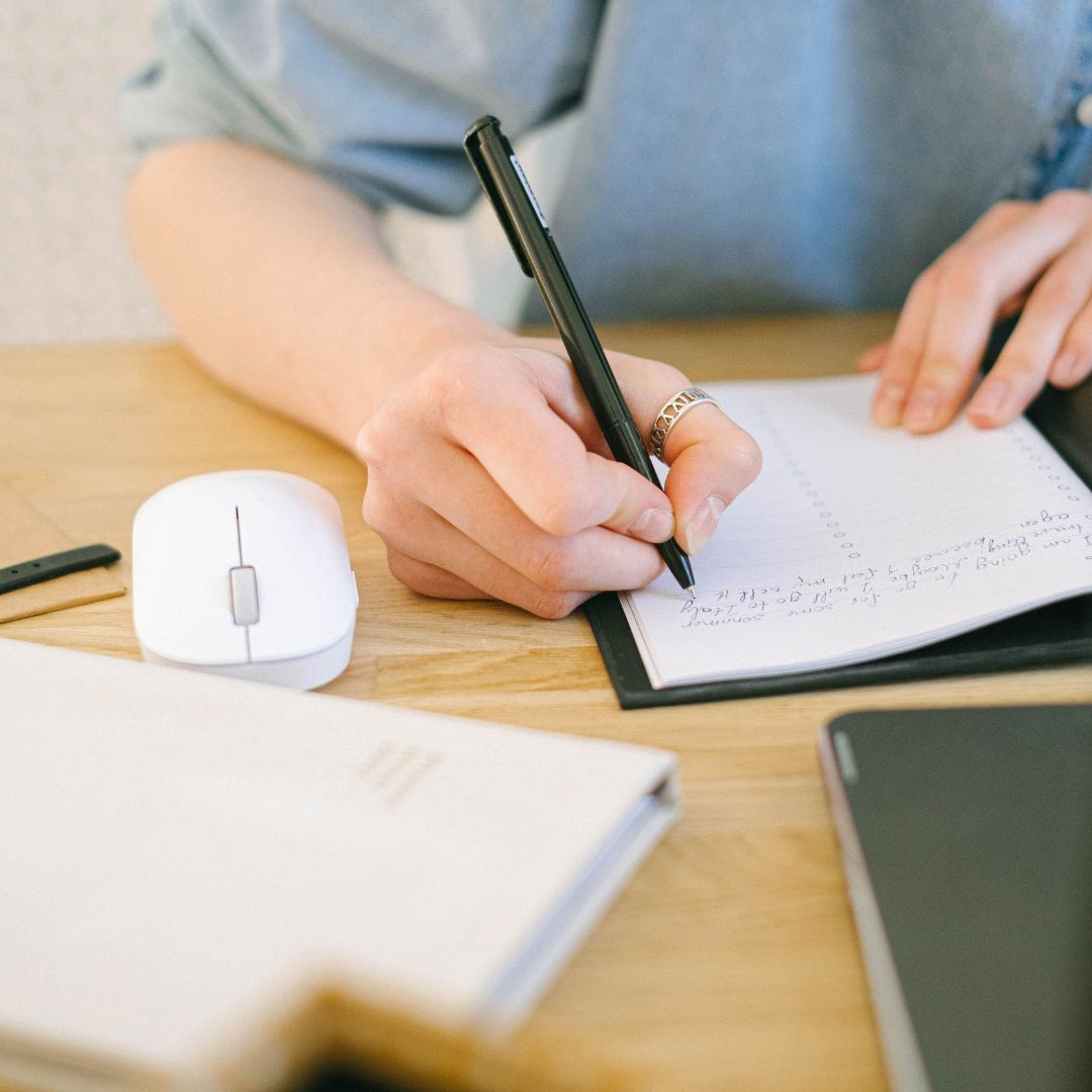 Student writing down a to do list in a notebook