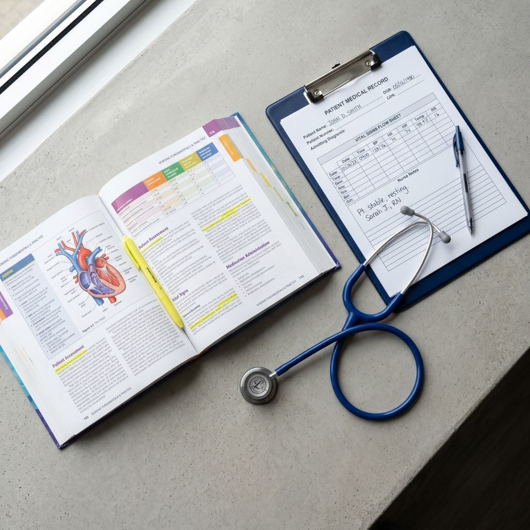 A professional flat lay of clinical nursing study materials, including a textbook and stethoscope.